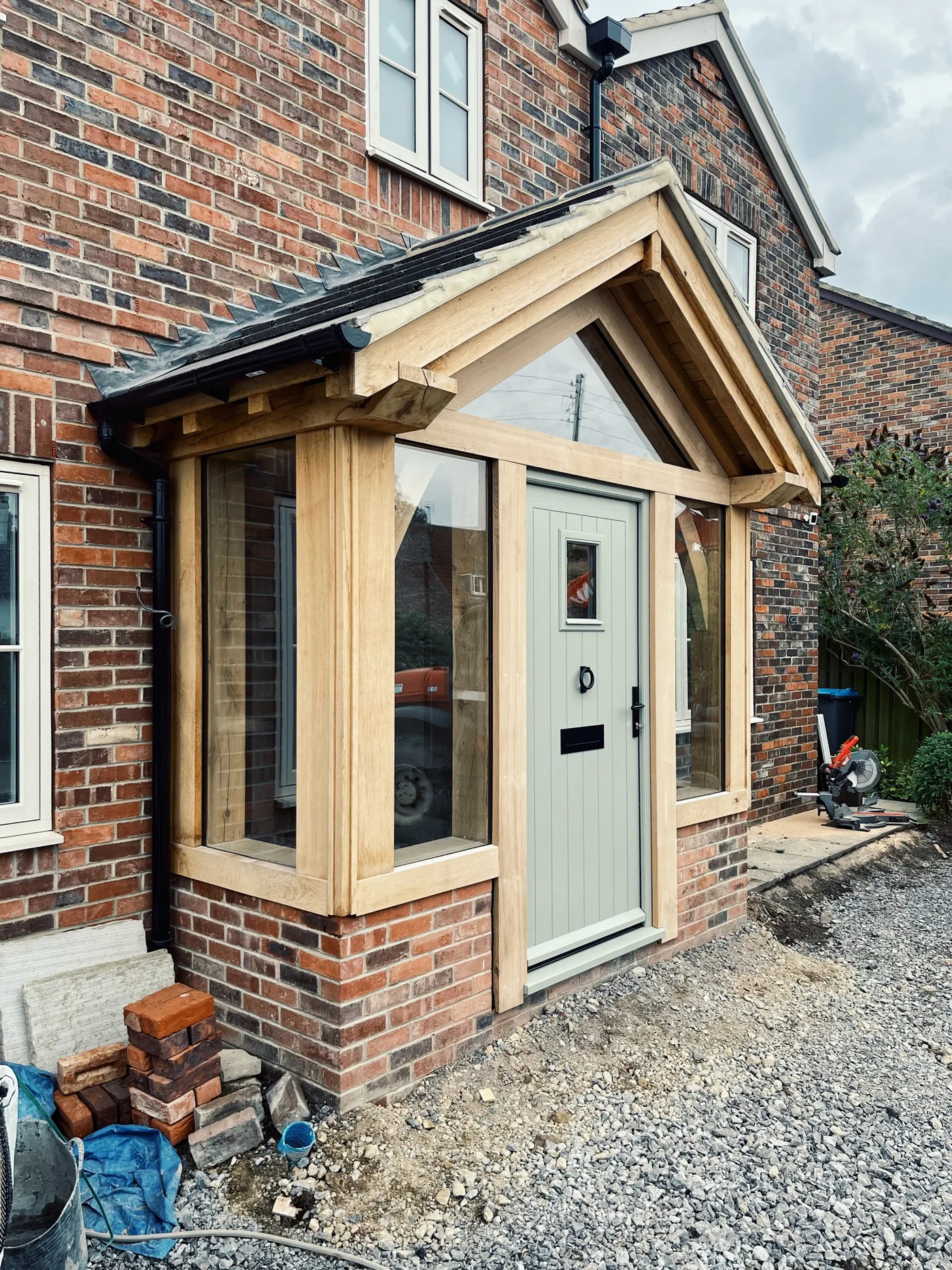 A timber-framed entrance with a pale green door