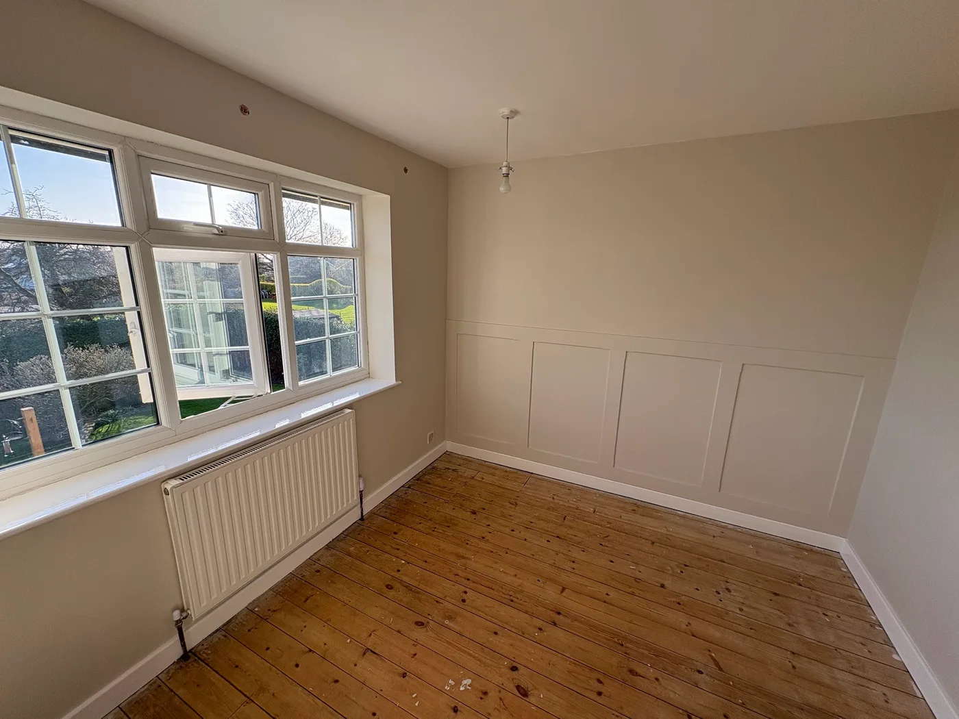 A light interior with timber flooring and wall panelling